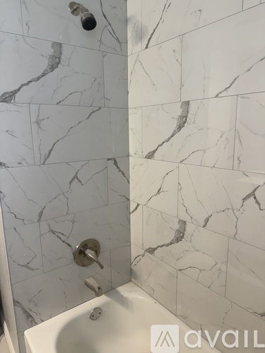 A white sink in a bathroom with marble tiles.
