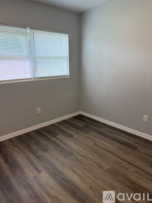 A room with a window and wooden flooring.