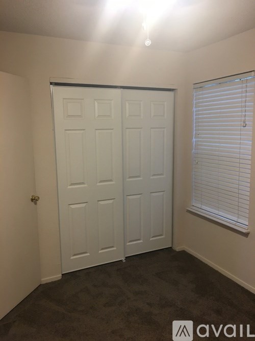 A white double door is in a room with carpeted flooring.
