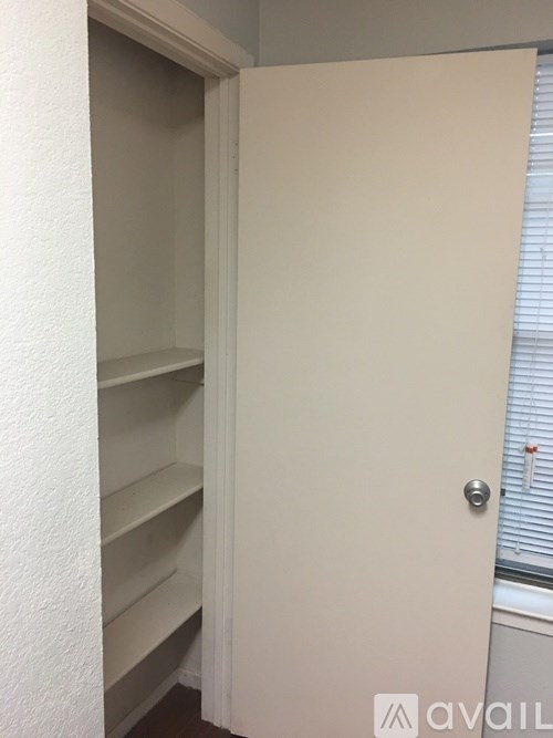 A white door with a silver handle is open.