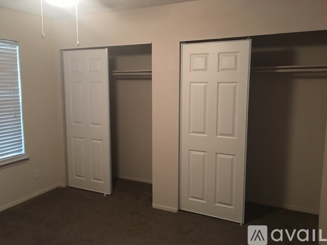 Two white doors in a room with carpeted floor.
