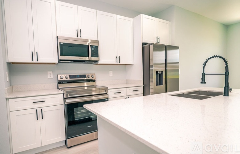 A kitchen with white cabinets and appliances.