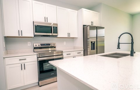 A kitchen with white cabinets and appliances.