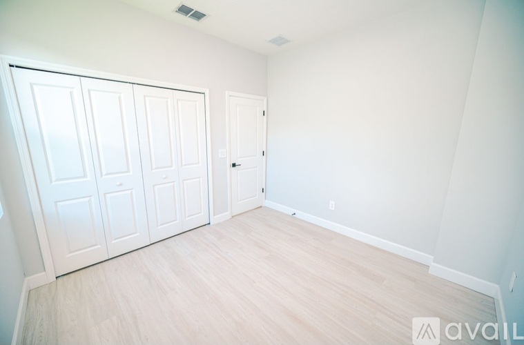 A room with white doors and wooden flooring.