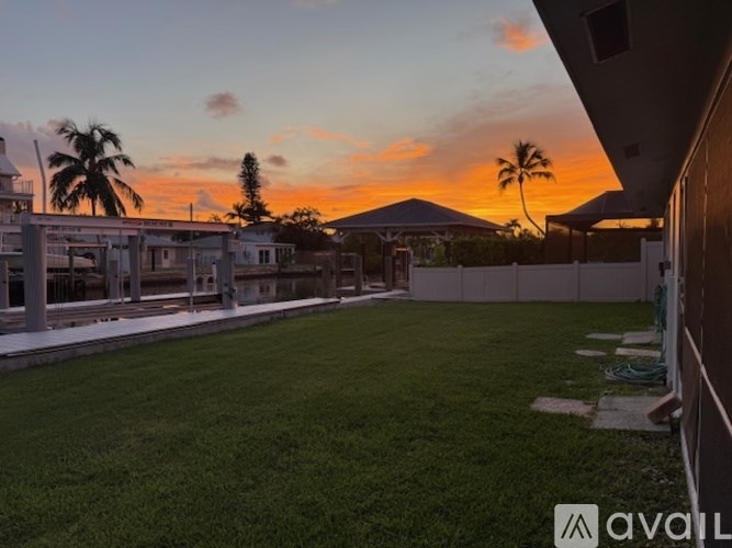 A sunset view of a residential area with houses and palm trees.