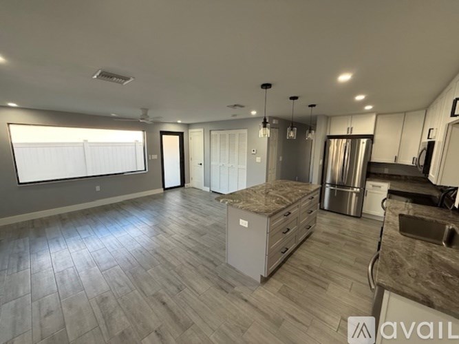 A spacious kitchen and living room with a large island in the middle.