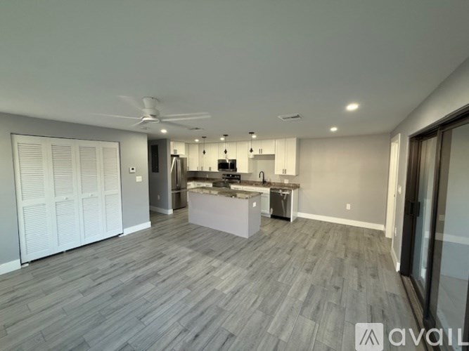 A spacious kitchen with a fan on the ceiling and a dining area with a table and chairs.