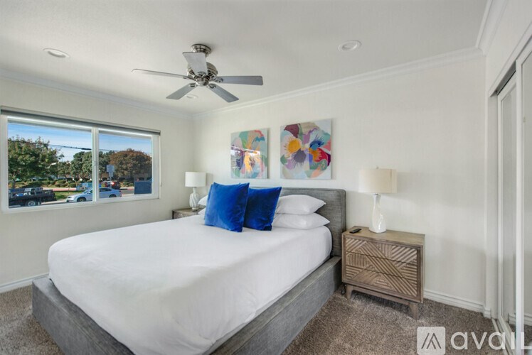 A bedroom with a large bed and a ceiling fan.