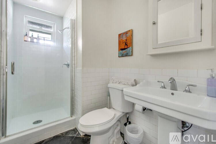 A bathroom with a toilet, sink, and shower.