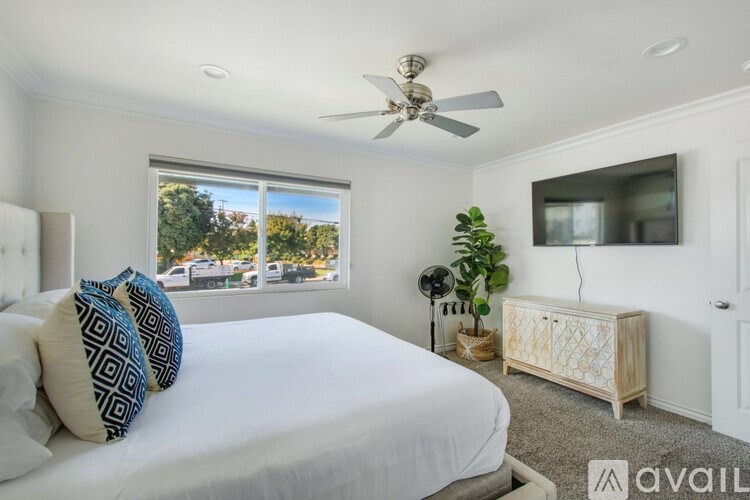 A bedroom with a large bed and a ceiling fan.