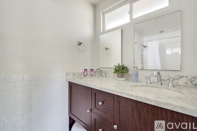 A bathroom with a marble countertop and a large mirror.