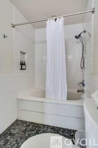A white bathroom with a tub and a shower.