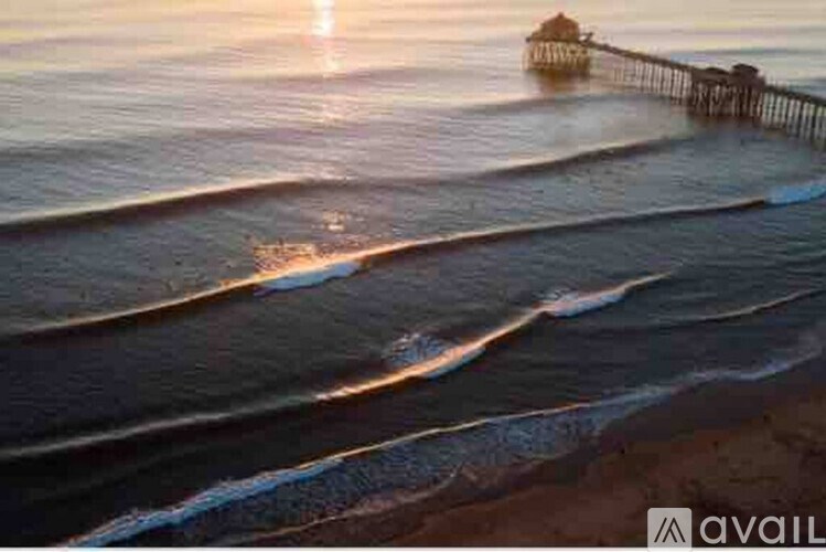 A sunset view of a beach with waves gently lapping at the shore.