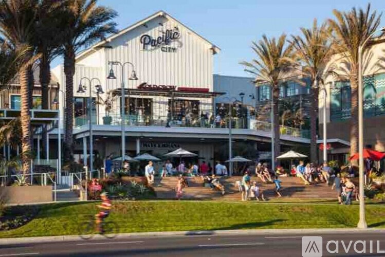 A busy outdoor scene with people walking and a building with a sign that says "Pacific".