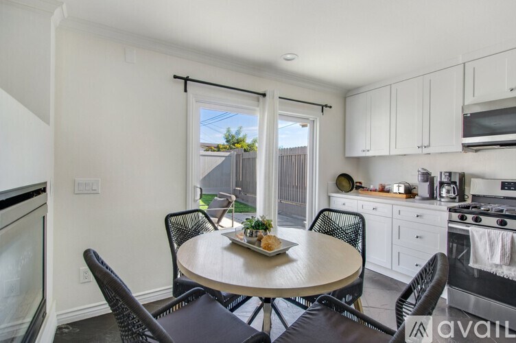 A kitchen with a table and chairs in front of a window.