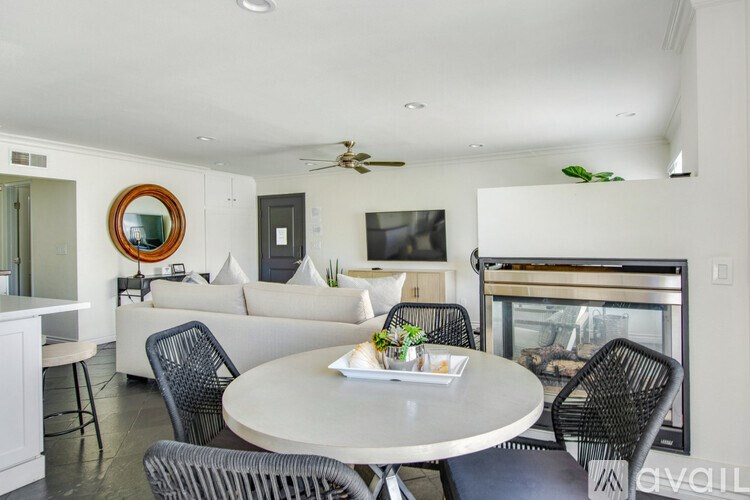 A modern dining room with a white table and chairs.