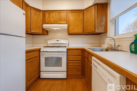 A kitchen with wooden cabinets and white appliances.
