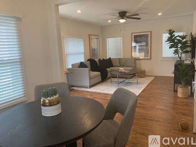 A living room with a black table and grey chairs.