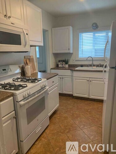 A kitchen with white appliances and cabinets.