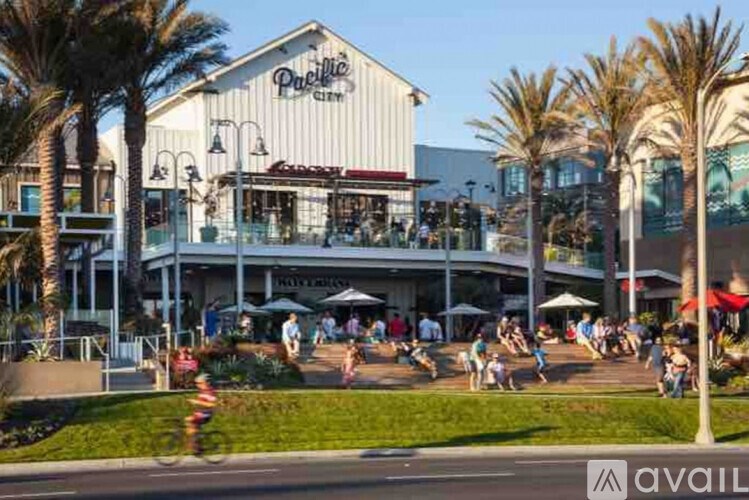 A busy outdoor shopping area with people walking and a large building with a sign that says "Public".