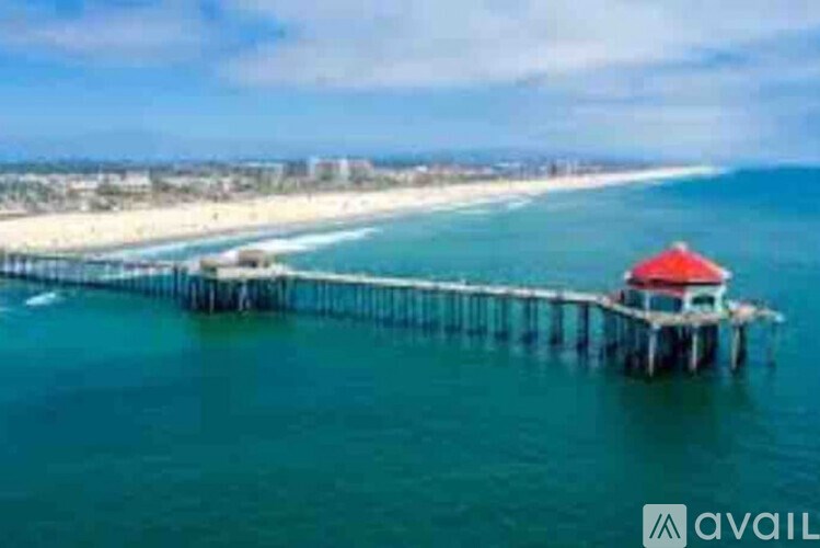 A pier with a red roof extends into the sea.