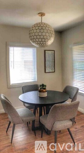 A dining room with a round table and chairs.
