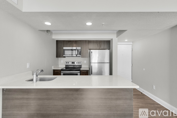 A modern kitchen with a stainless steel refrigerator and a sink.
