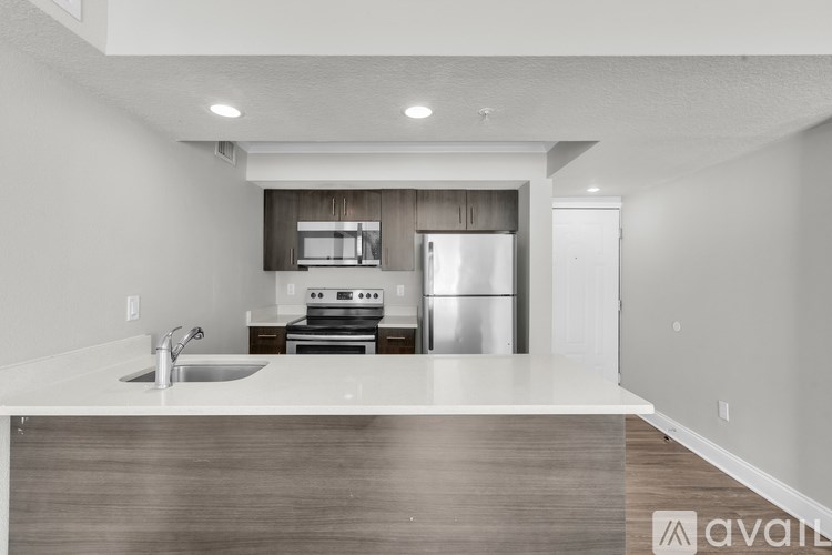 A modern kitchen with a stainless steel refrigerator and a sink.