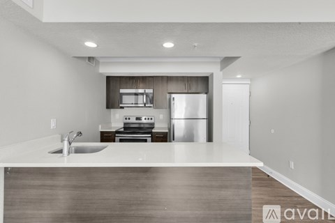 A modern kitchen with a stainless steel refrigerator and a sink.