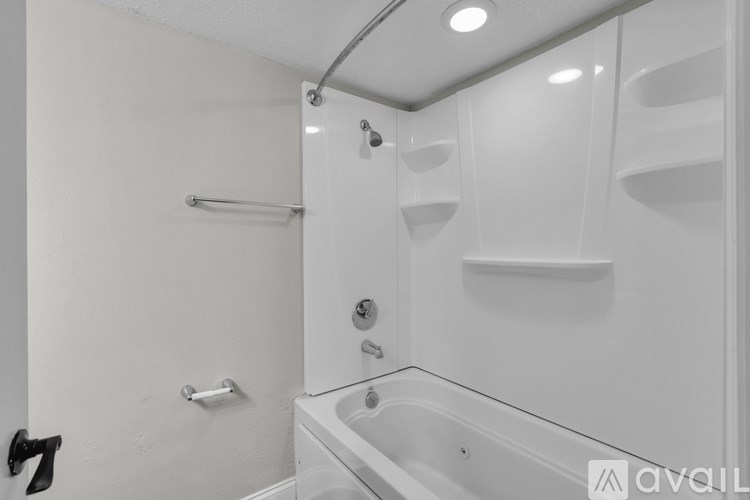 A white bathroom with a tub and a shower.