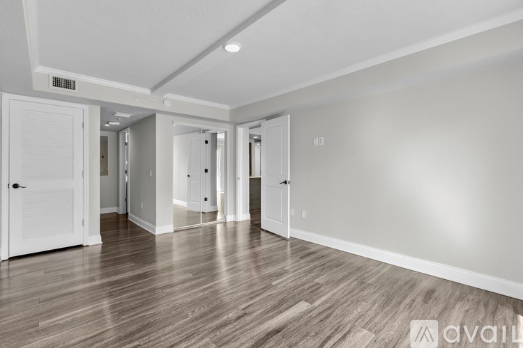 A spacious room with wooden flooring and white walls.