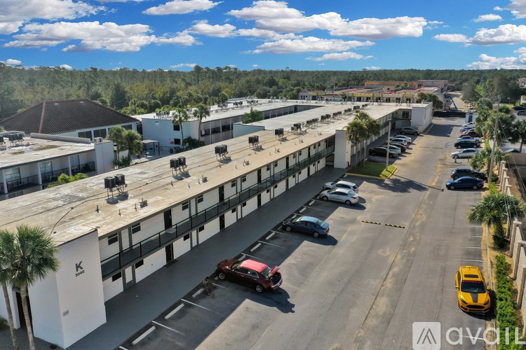 A parking lot with cars and a yellow taxi.