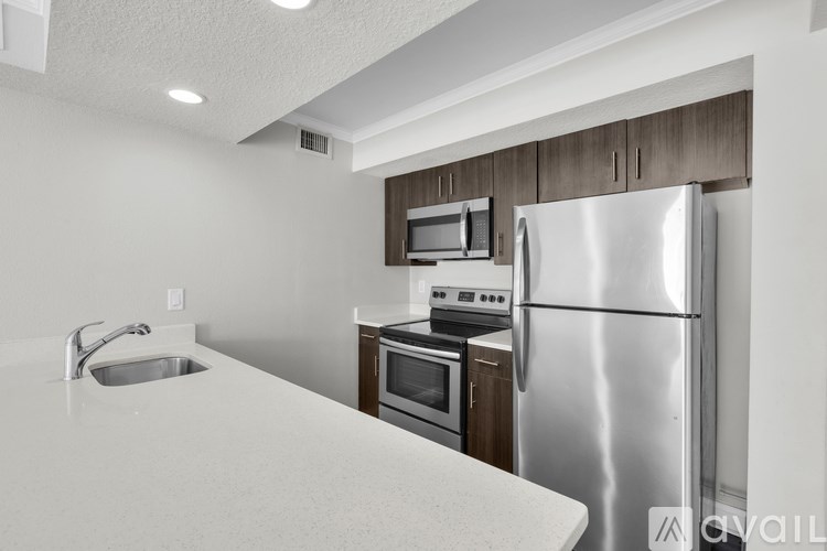 A kitchen with a stainless steel refrigerator, microwave, oven, and sink.