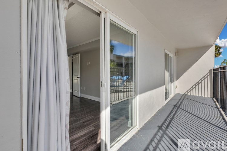A balcony with a glass door leading to a patio.