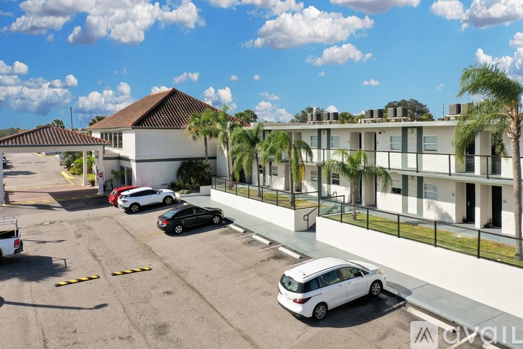 A parking lot with cars and a building with balconies in the background.