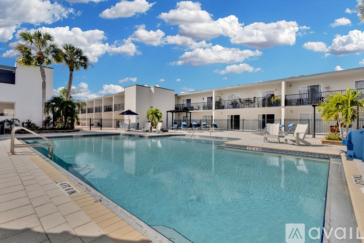 A large swimming pool in front of a building with palm trees.
