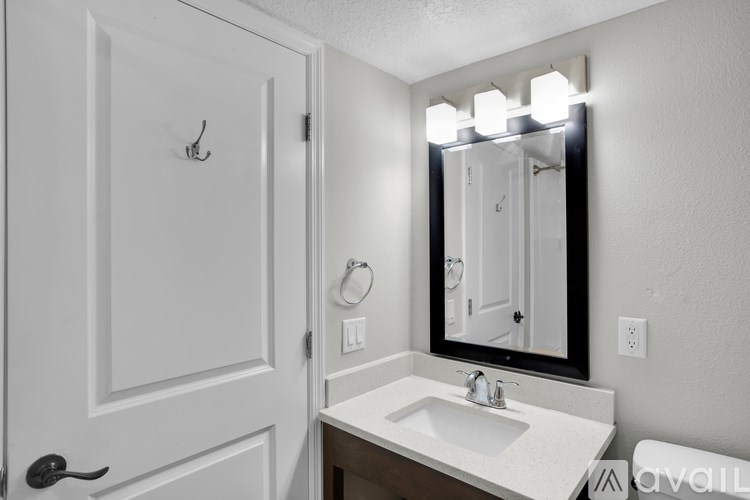 A white bathroom with a sink and mirror.