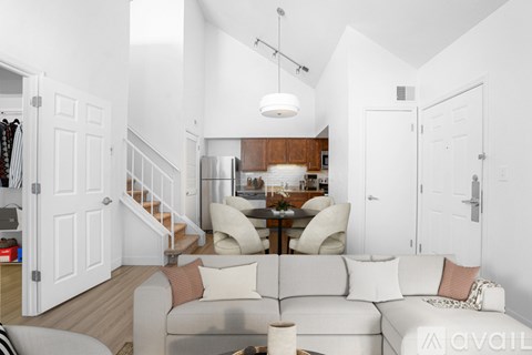 A modern living room with a grey sofa and a wooden dining table.