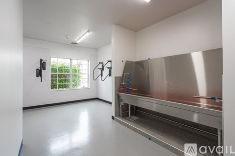 A clean, empty room with a large metal table and a window.