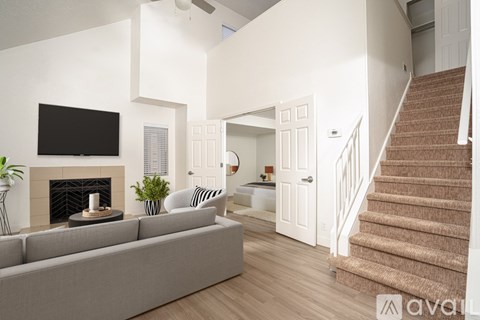 A living room with a grey couch and a fireplace.