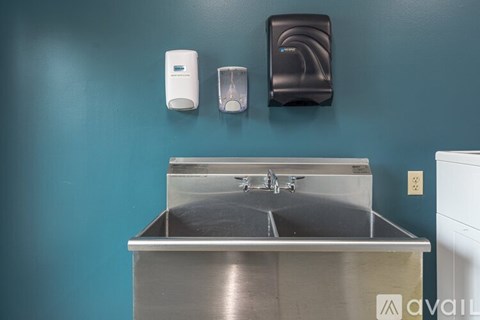A bathroom sink with a soap dispenser and hand dryer.