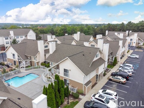 A large apartment complex with a pool and a parking lot.