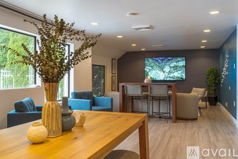 A modern living room with a wooden table and a flat screen TV mounted on the wall.