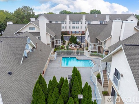 A bird's eye view of a residential area with a swimming pool and apartment buildings.