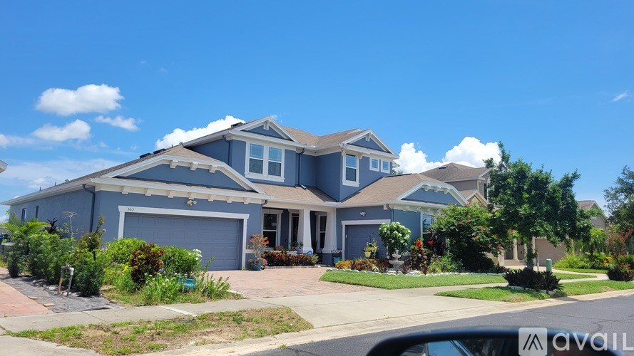 A blue house with a car parked in front.