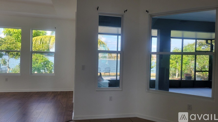 A room with two windows and a door is available for rent.