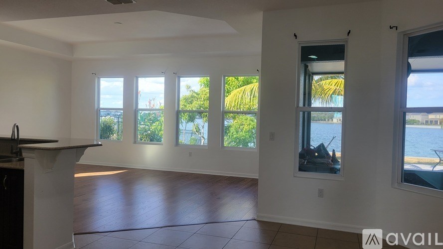 A spacious room with a kitchen island and large windows overlooking the water.