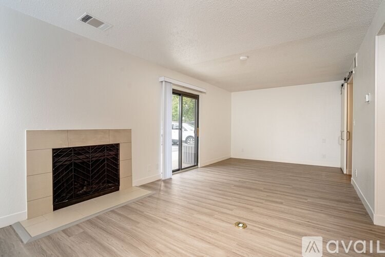 A living room with a fireplace and sliding glass doors.