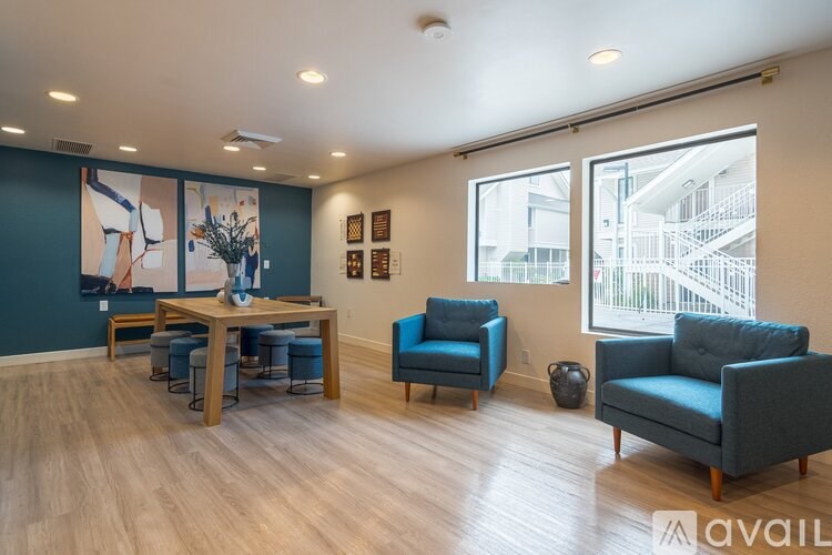 A living room with a blue chair and a table.