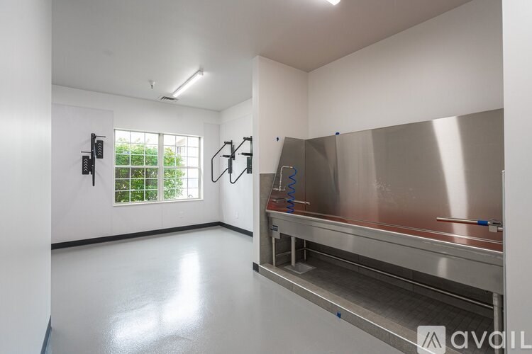 A clean, empty room with a large metal table and a window.